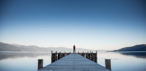 The Secret to finding the best candidate - zoomed out image of someone standing on a dock in the early morning