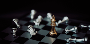The Secret to finding the best candidate - silver chess pieces lying around one standing gold piece