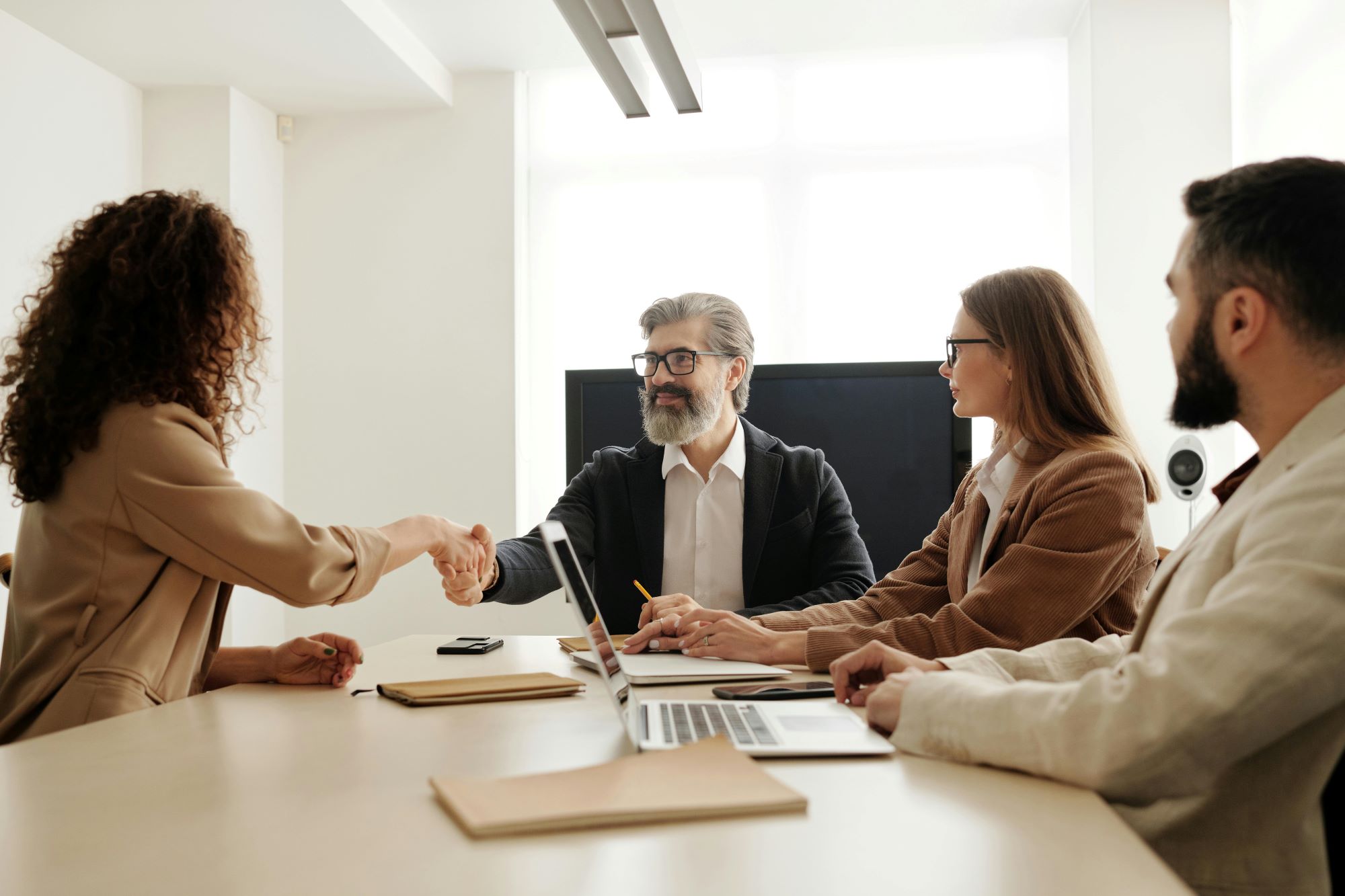 HR director shaking hands with other HR professionals around a table